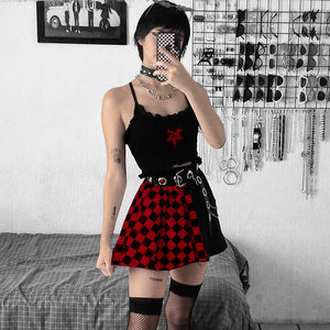 Spiegelselfie in de rood-zwart geruite minirok met een zwarte cami top, oogjesriem en visnetkousen