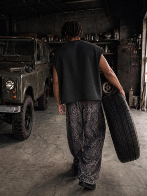 Seen from behind carrying a tyre, the dropped armhole leaving the whole shoulder and arm free