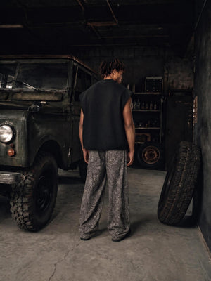 Full-length back view in the workshop, showing how short the body is cut against baggy trousers