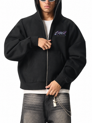 Man wearing the Chrome Y2K Zip Up Hoodie open over a white tee, hood up, hands on the metal zip
