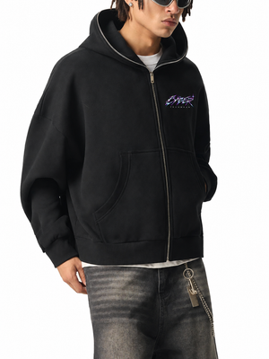Three-quarter view of a man in the Chrome Y2K Zip Up Hoodie, hood up, one hand in a front pocket