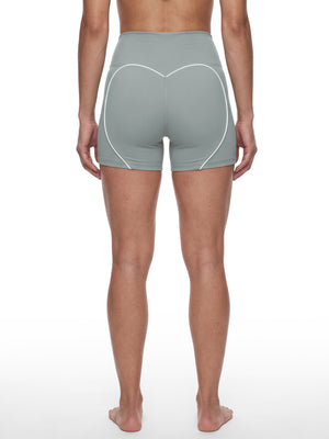 Back view on a model in haze blue, the white heart trim framing the seat above mid-thigh hems