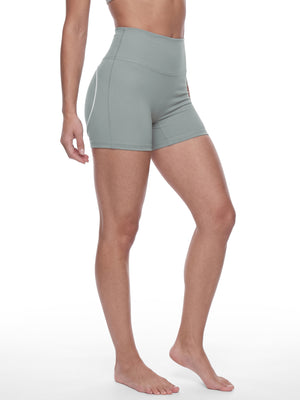 Side view of the model in haze blue booty shorts, the high waistband sitting well above the hips