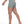 The model walking in the haze blue shorts, seen from the back, the trim following the curve of the seat