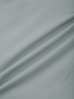 Close-up of the smooth haze blue nylon and spandex knit, a flat seam running across it