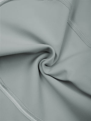 The haze blue fabric twisted to show its stretch and the soft sheen of the thin knit