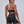 A model wears the black booty shorts from behind, the white heart trim curving over the seat