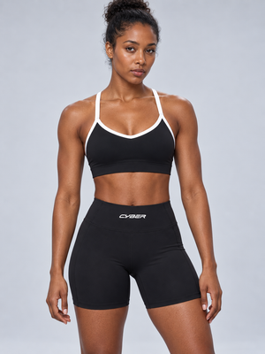 Front view on the model in the black booty shorts and matching color block sports bra
