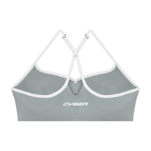 Back of the haze blue sports bra laid flat, the Y straps and the CYBER wordmark on the band