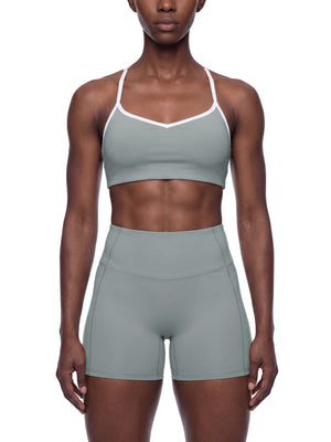 A model wears the haze blue color block sports bra with matching shorts, front view