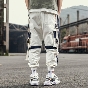 Back of the white colorblock pants, navy knee bands, side buckle straps and ribbed ankle cuffs
