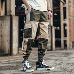 Army green and khaki colorblock pants worn with high-top sneakers, front view, big flap cargo pockets