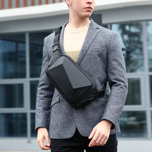 Small black chest bag with angular panels and a single zip