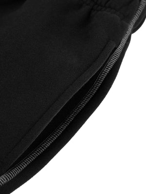 Detail of the side pocket opening on the black fleece sweatpants, edged with grey contrast topstitching