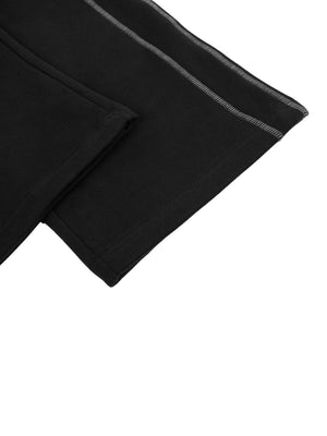 Close-up of the straight open hem of the black baggy sweatpants, with the grey contrast seam along the leg