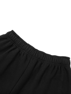 Back waistband detail of the black oversized sweatpants, showing the gathered elastic and soft fleece