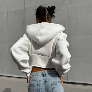 Back view of a woman in the white cropped hoodie with the hood down and puffed dropped shoulders