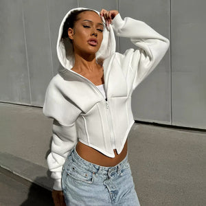 Woman in the white corset hoodie with the hood up, three-quarter view of the zip and pointed waist seams