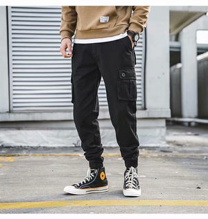 Cropped Cargo Cyberpunk Pants in black worn with high-top sneakers, front view, big flap cargo pockets
