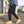 Black cargo pants worn with tan boots, three-quarter view, thigh pocket and cuffed cropped leg