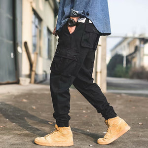 Black cargo pants worn with tan boots, three-quarter view, thigh pocket and cuffed cropped leg
