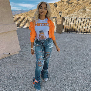 Orange denim jacket cropped above the waist, walking front view with distressed flared jeans