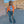 Orange coloured denim jacket with chest flap pockets, front view holding a small grey bag