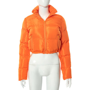 Orange quiltet kort jakke på en mannequin, frontvisning med kanten trukket ind af snøren