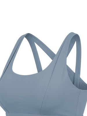 Side view of the gray blue yoga bra, a wide strap curving from the shoulder around to the back