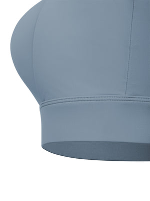 Close-up of the elastic under-band, a wide flat hem finishing the gray blue knit