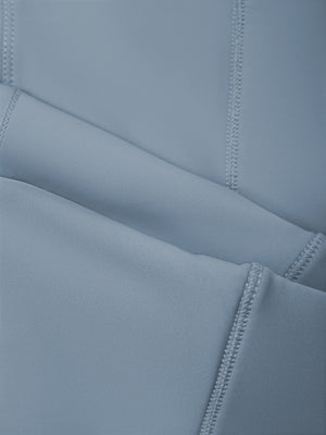 Close-up of a curved front seam, stitched flat into the smooth gray blue knit