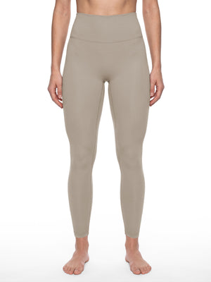 Front view on a model in the khaki high waisted yoga leggings, the waistband above the navel
