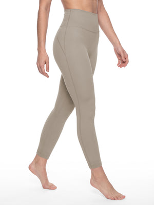 The model walking in the khaki leggings, three-quarter view, the knit following the leg