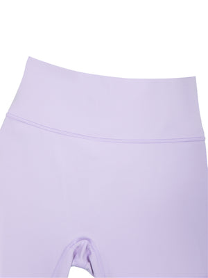Close-up of the purple front waistband, wide and flat, joined to the leg with a curved seam