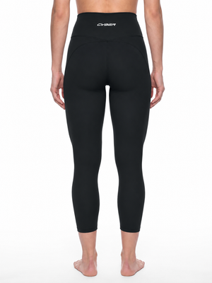 Front of the black leggings on the model, a wide high waistband and legs ending above the ankle