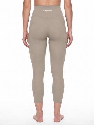 Back view on a model in the khaki yoga leggings, the seams curving under the seat