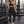 A woman in a gym wears the black yoga leggings with a black sports bra, seen from behind
