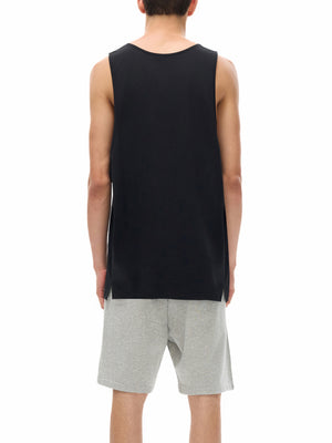 Back view on the model in the black muscle shirt, a small slit at each side of the hem