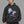 Man in a black beanie wearing the Embryo Portrait hoodie, front view of the purple-blue face print and white lettering