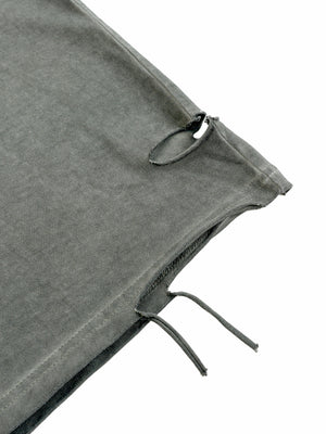 Close-up of the raw distressed hem, with a torn opening and loose threads left hanging at the seam