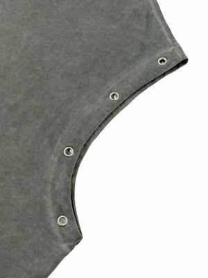 Close-up of one armhole, a row of metal eyelets set through the washed cotton along the edge