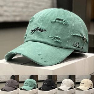 Green distressed baseball cap with script embroidery and a brim ring