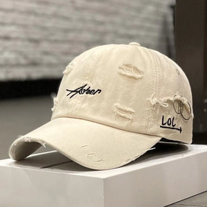 Green distressed baseball cap with script embroidery and a brim ring
