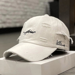 Green distressed baseball cap with script embroidery and a brim ring