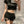 Close front view of the black high waist shorts, button waist and two buckle straps across a side cut-out