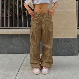 Brown parachute y2k pants on a woman in a white crop tee, front view of the baggy legs and thigh cargo pockets