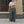 Grey parachute cargo pants worn low on the hips, front view with one arm raised and pink and white sneakers