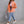 Orange distressed denim shacket worn open, walking full length view with a grey backpack and sneakers