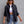Black frayed denim jacket worn open over a white crop top, front view with sunglasses and light jeans
