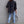 Back view of the Black oversized Y2K jacket with frayed hem, worn with skinny jeans and white sneakers